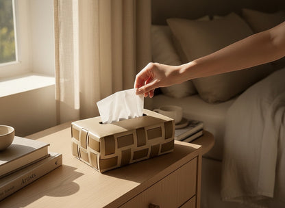 Kra Design beige genuine leather tissue box with woven pattern and ultra suede lining, on a wooden nightstand.