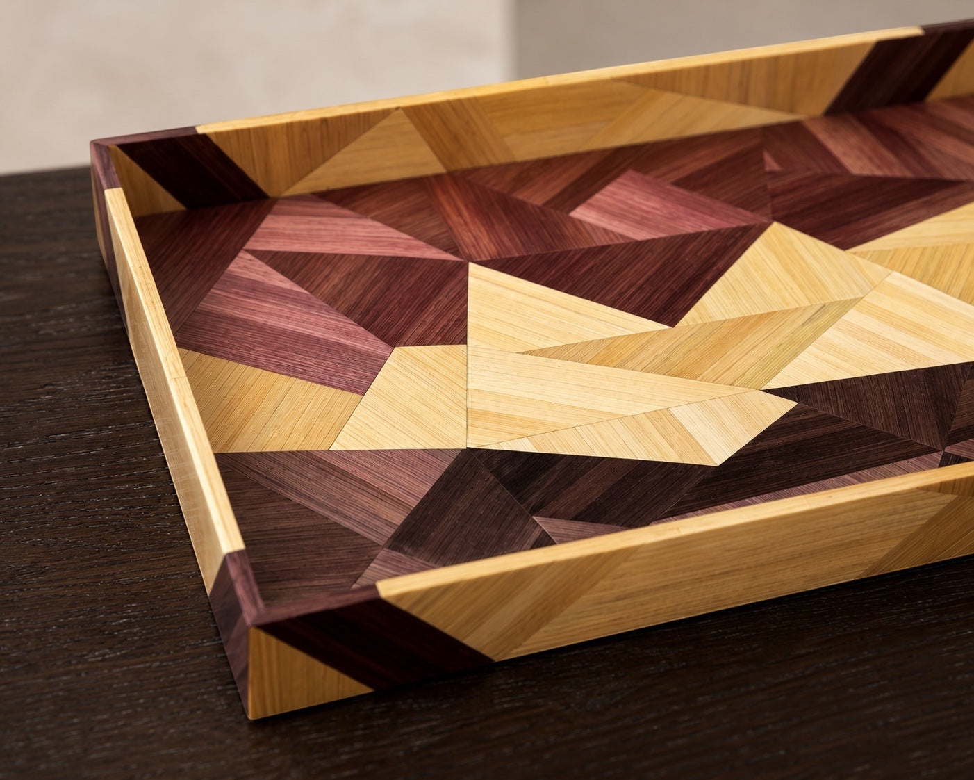Kra Design geometric straw inlay decorative tray with warm wood tones and intricate mosaic pattern.