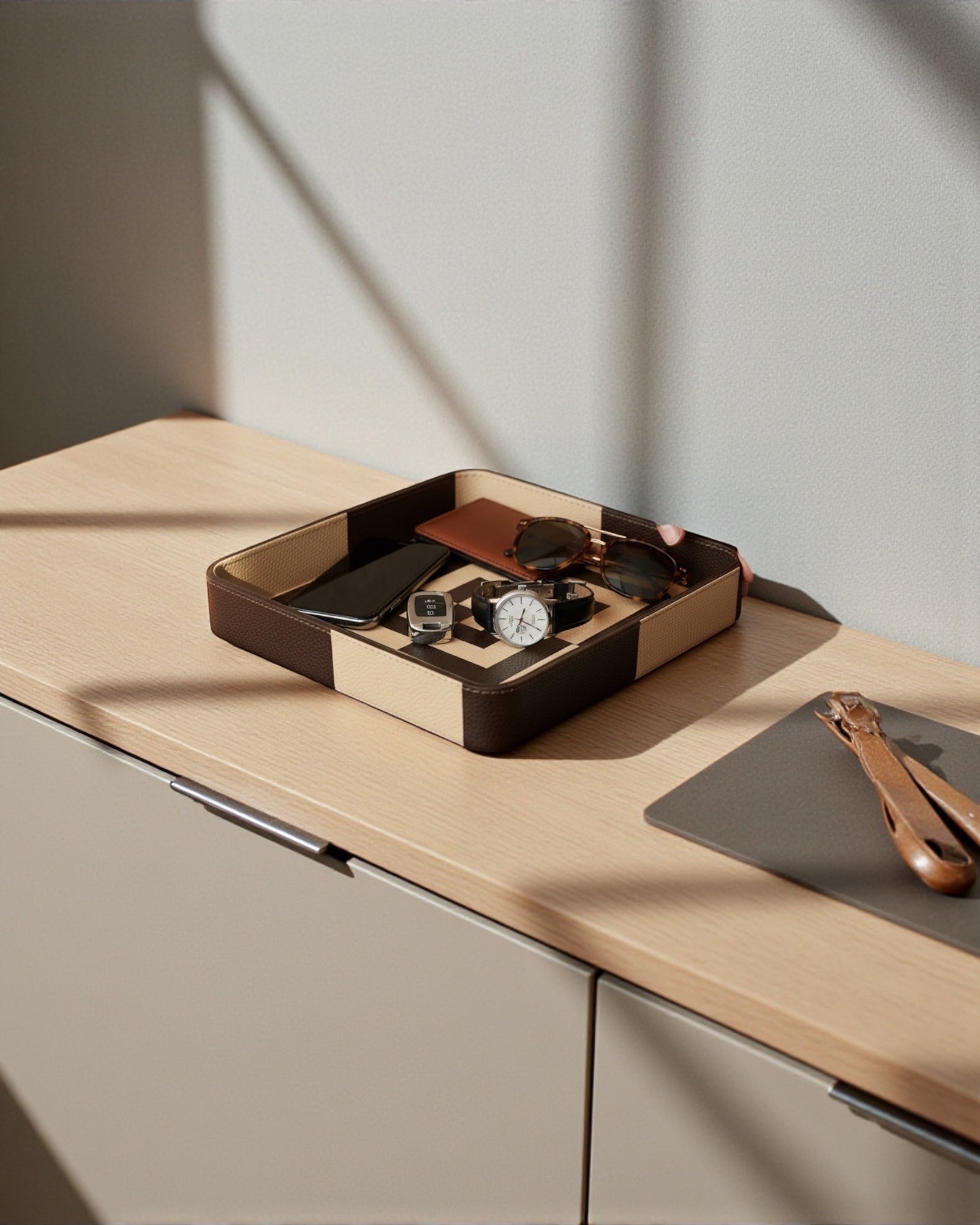 Kra Design luxury leather vanity tray with geometric detailing, holding a phone, watch, sunglasses, and wallet.